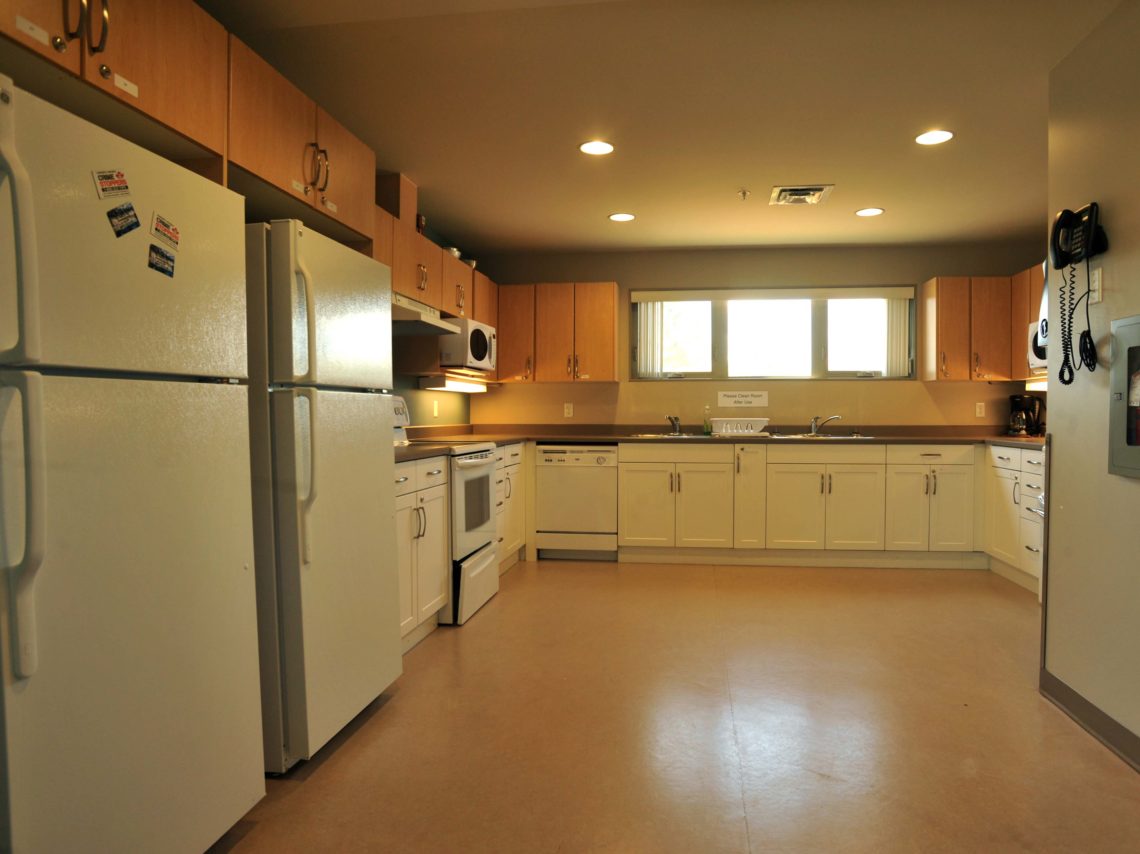 Common kitchen with fridge, oven and cupboards