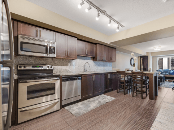 Kitchen with tiled floor, dark cabinets and granite counter tops