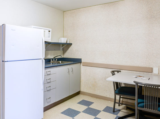 Common area kitchen with fridge and tables