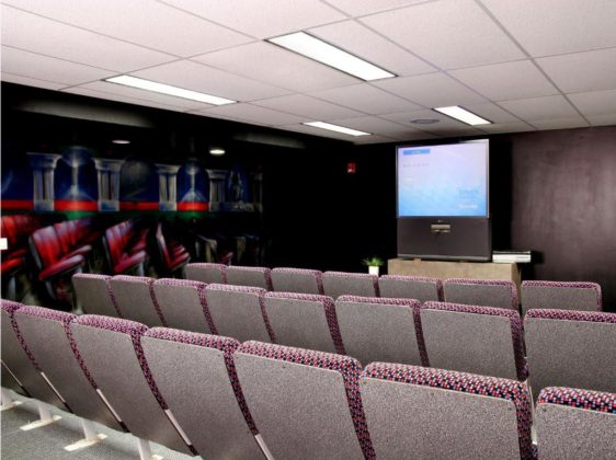 Theatre room with multiple theatre chairs and large tv screen