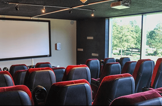theatre room with large screen and movie theatre style chairs