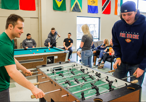 students in games room with pool table and fuseball table