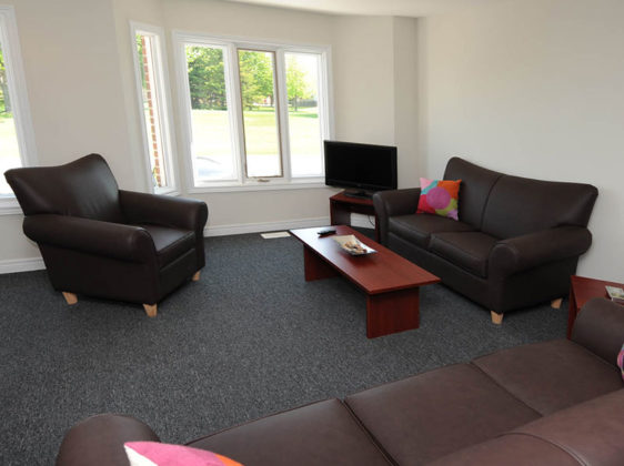 Student residence living room with 2 couches, a chair and tv