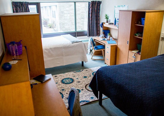 Student residence room with bed, desk and storage space