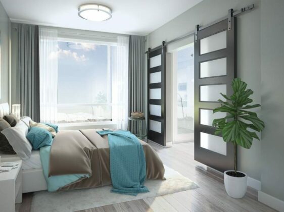 Grey bedroom, with teal decor accents, large tropical plant, and sliding doors.