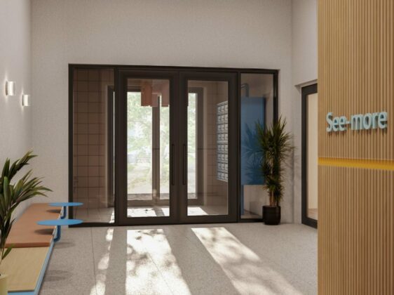 See-More lobby entrance with tropical plant and bench with blue tables.